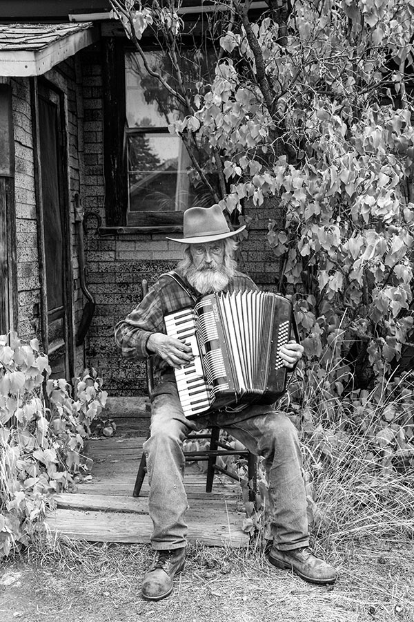 Elderly rancher playing the accordion.